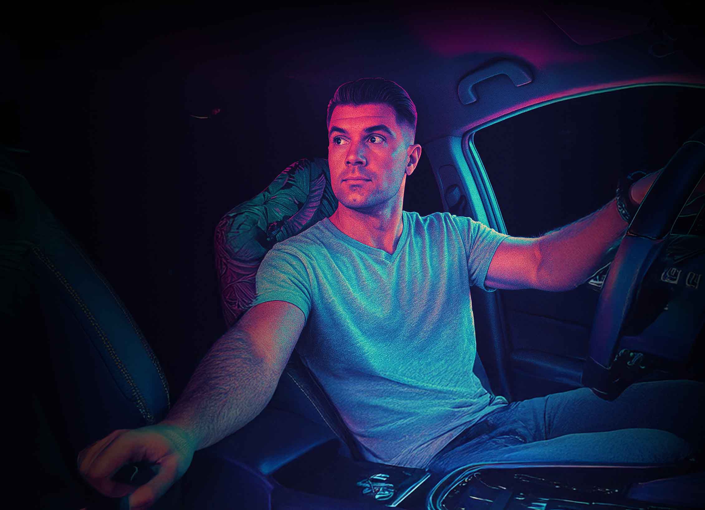 Man driving a car with neon lighting